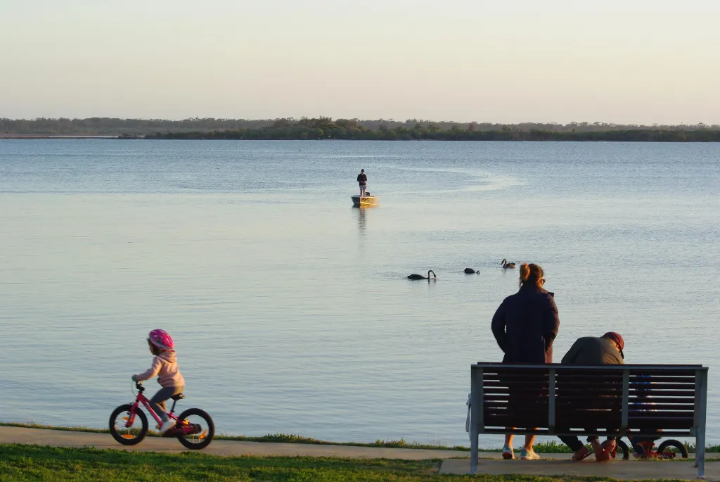 Family relaxing by the lake at Metung